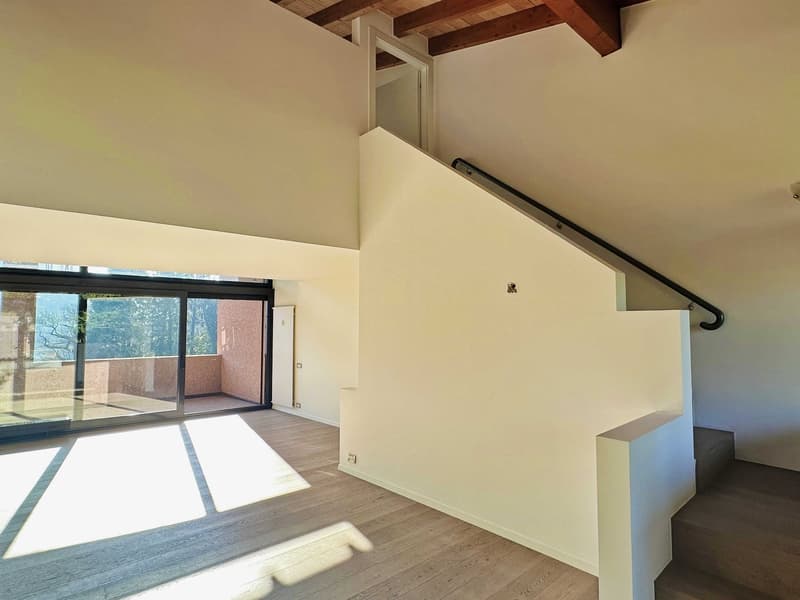 Empty room with wooden floor, white walls, glass sliding doors, wooden ceiling, staircase
