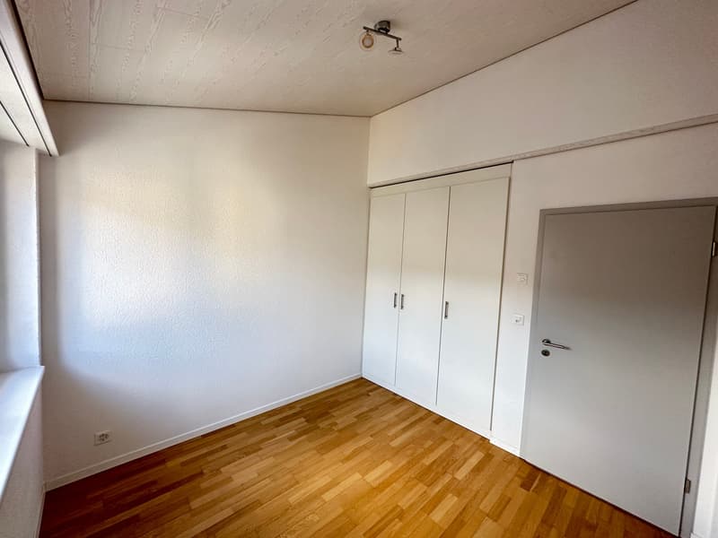 empty room, white walls, wooden floor, white wardrobe, power outlet, window