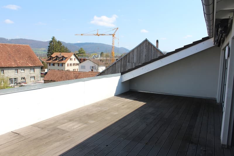 wooden deck, white wall, view of the mountains, crane in the distance