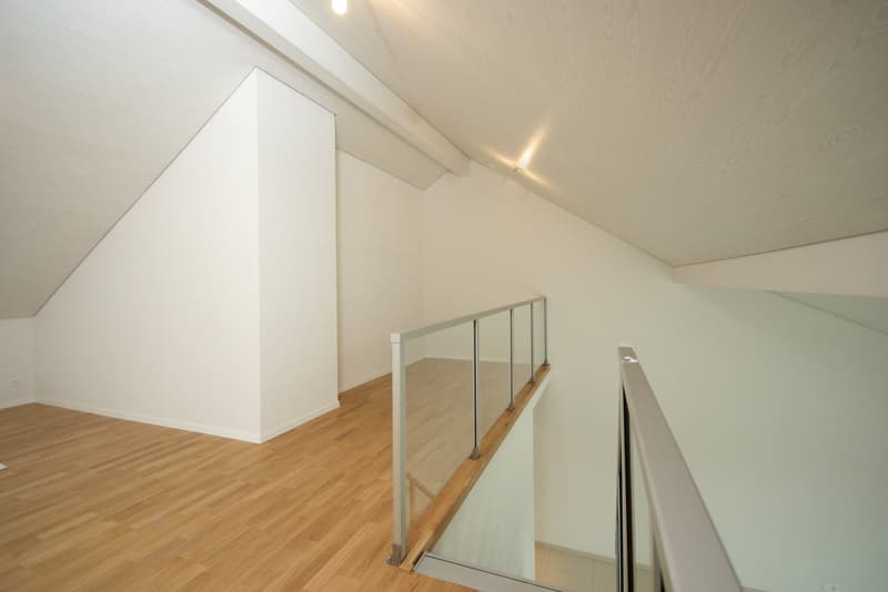 empty room, wooden floor, white walls, glass railing, sloped ceiling
