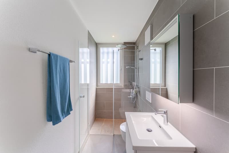 modern bathroom with shower, sink, toilet, towel, mirror, tiled walls