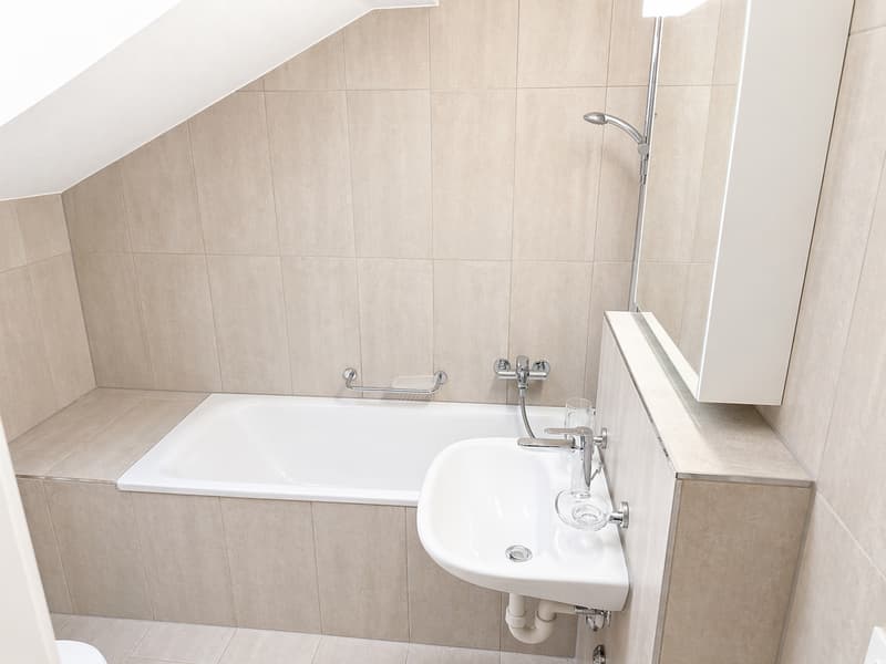 Bathroom with bathtub, sink, mirror, and shower head