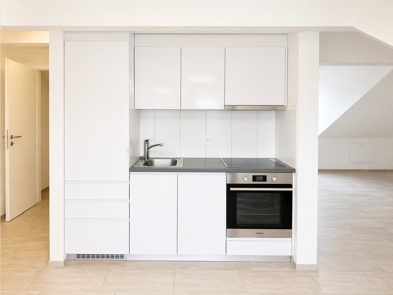 modern kitchen with white cabinets, stainless steel appliances, tiled floor, open door