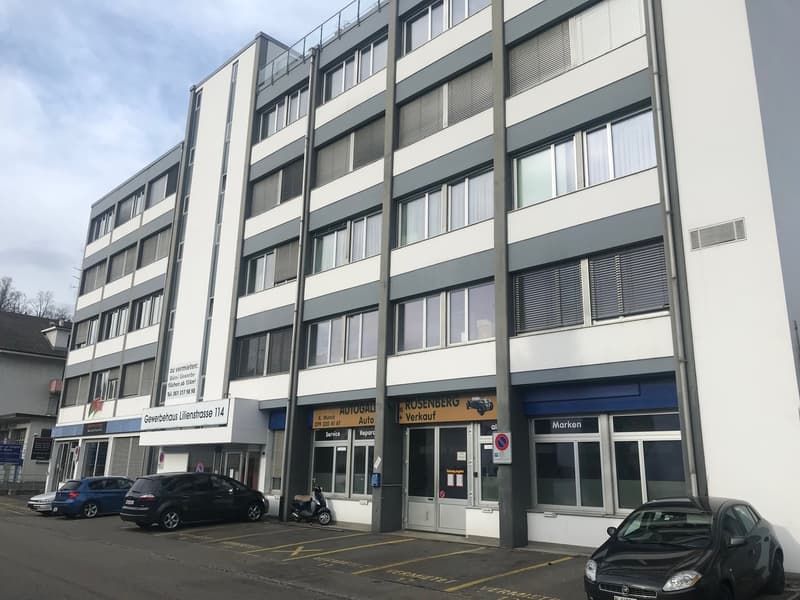 4 story building, grey and white exterior, large windows, garage