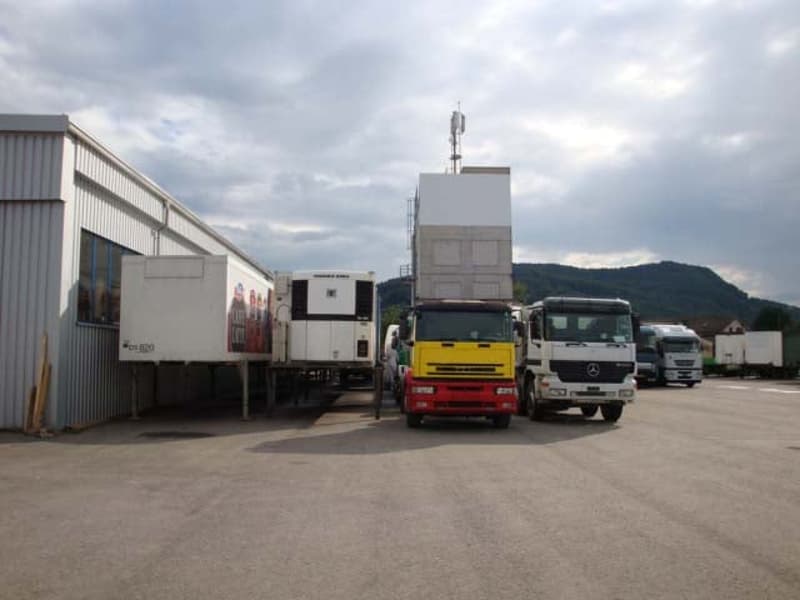 Exterior of commercial property with trucks parked in front.