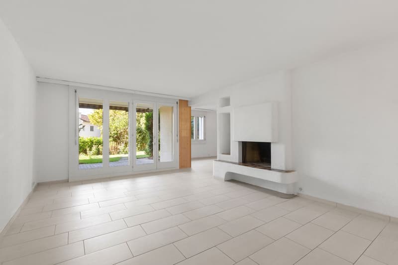 Grosses Wohnzimmer mit Cheminée und Zugang zur Terrasse