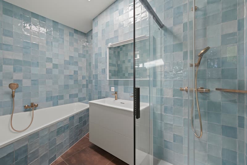 Salle de bains  / a bathroom with blue tiles on the walls and a white sink