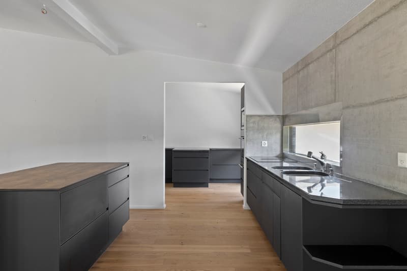 Cuisine / a large kitchen with black cabinets and white walls