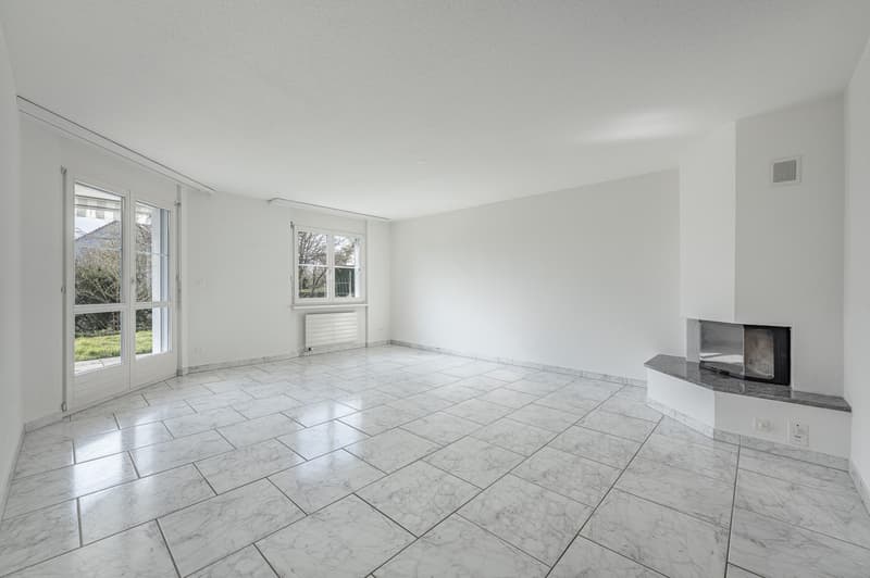 Wohnzimmer mit Cheminée und Ausgang zum Garten