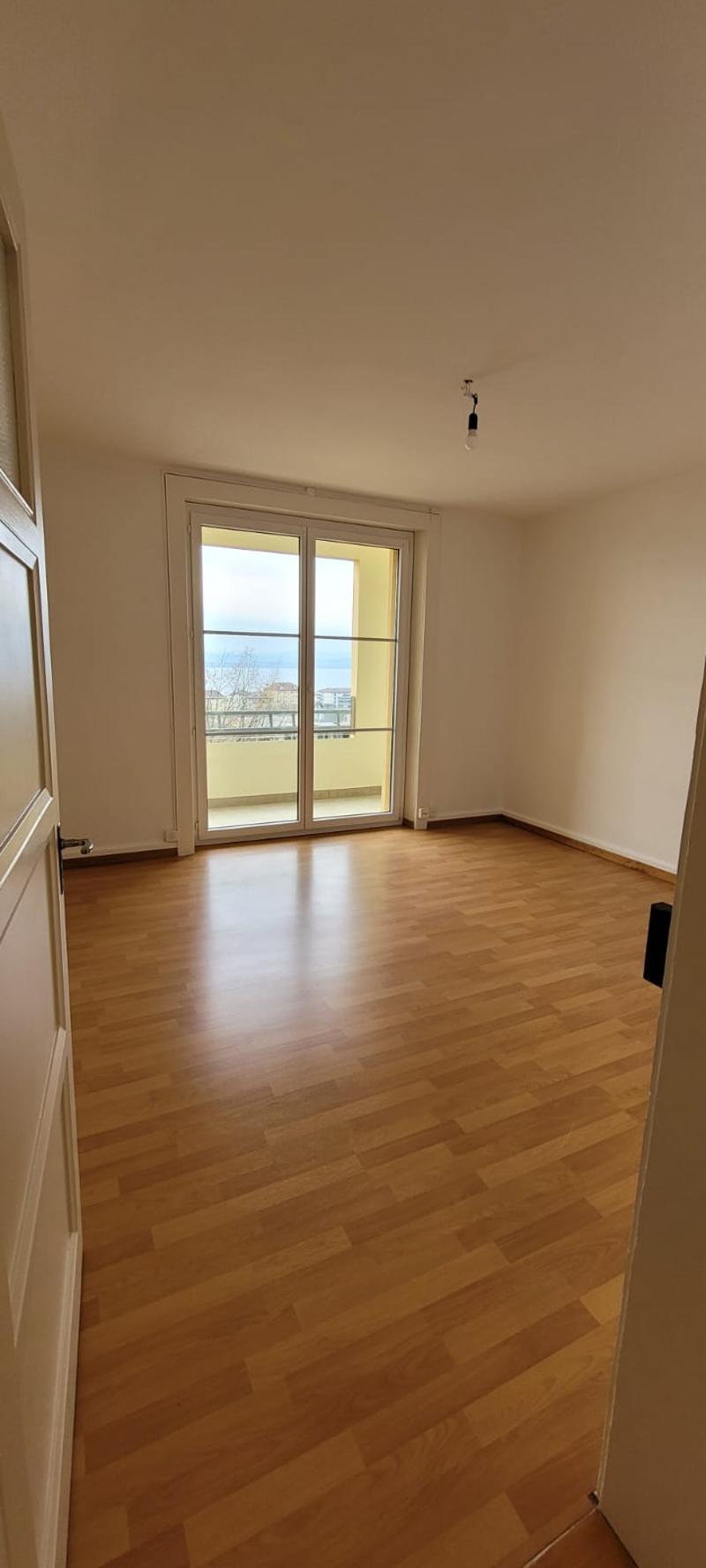 empty room, wooden floor, glass door leading to a balcony