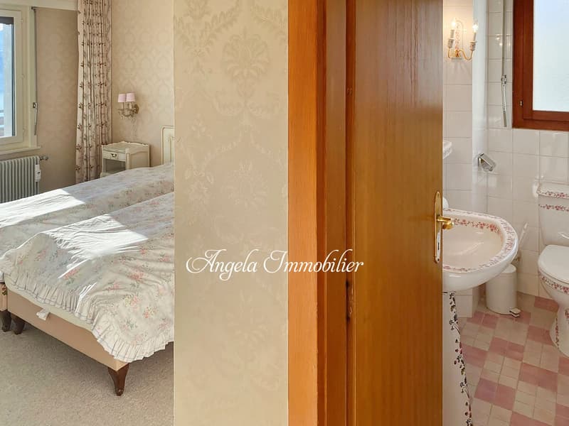 Bedroom with two beds, nightstand, radiator, wallpaper, bathroom with toilet, sink, window