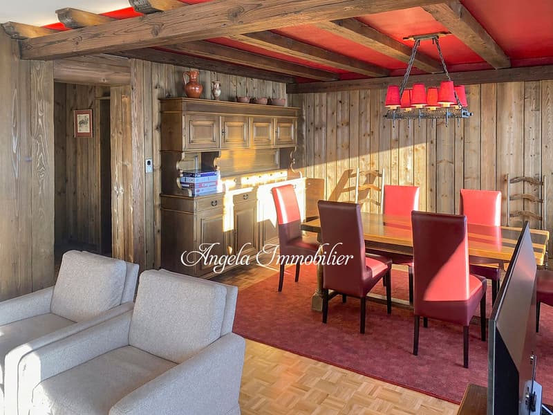 wooden walls, wooden floor, dining table with 6 chairs, wooden cabinet, chandelier, couch, TV