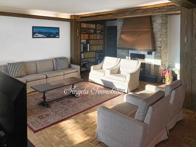 wooden floor, fireplace, bookshelves, couches, coffee table, rug, TV