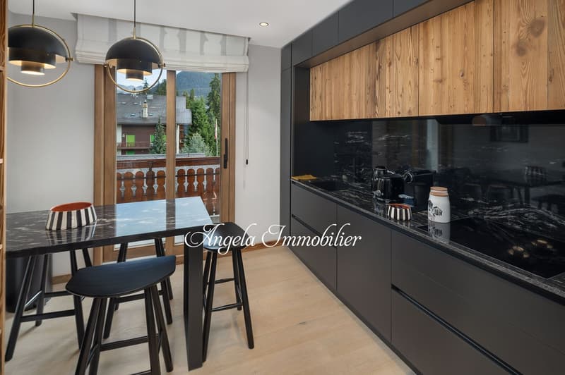 modern kitchen with black marble countertops, wooden cabinets, black stools, dining table, large windows, balcony
