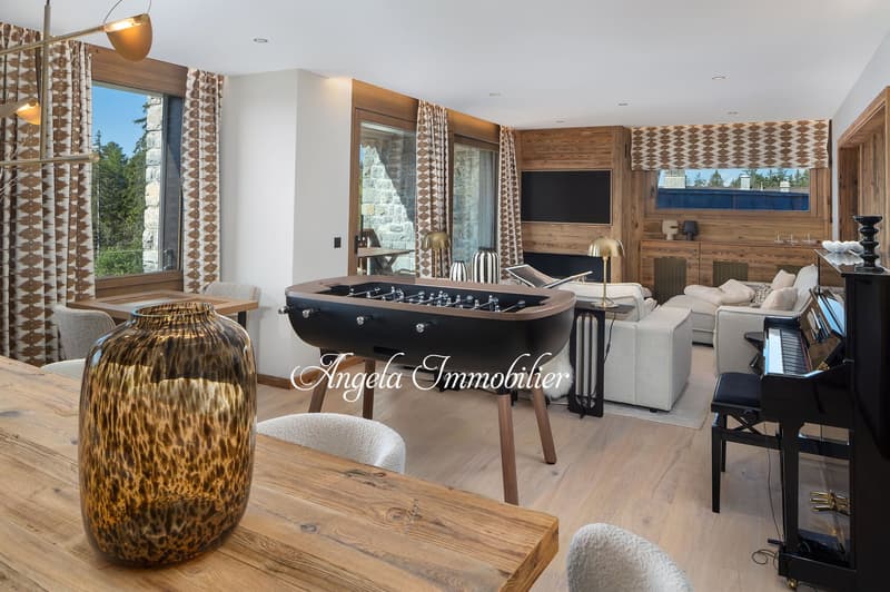 living room with wooden floor, large windows, fireplace, foosball table, piano, couches, and a table