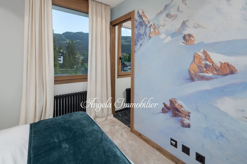 bedroom with bed, large window, mural, radiator, carpet