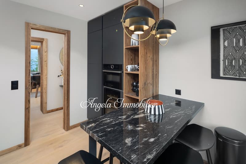 modern kitchen with marble countertop, wooden cabinets, black stools, black trash bin, black pendant lights, black and white bowl, black and white mug, black oven, wooden door, wooden floor