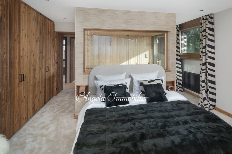 large bed, wooden wardrobe, carpeted floor, large window, wooden wall, radiator