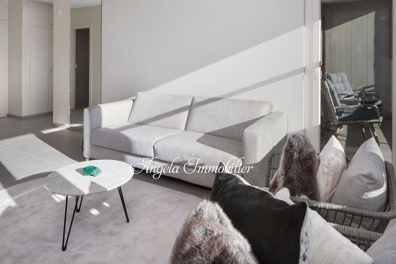white walls, beige carpet, white sofa, gray coffee table, wicker chairs on balcony, view of terrace