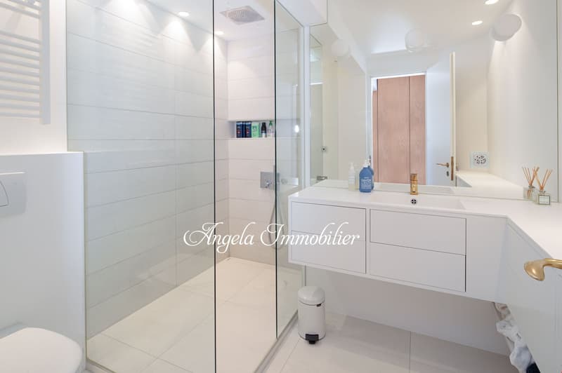 white tiles, glass shower, white vanity, gold fixtures