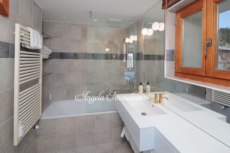 white bathtub, walk-in shower, vanity, mirror, towel rack, tiles