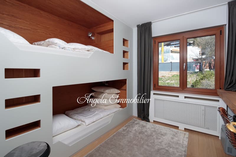 Built-in bunk bed, wooden shelves, radiator, large window, gray rug