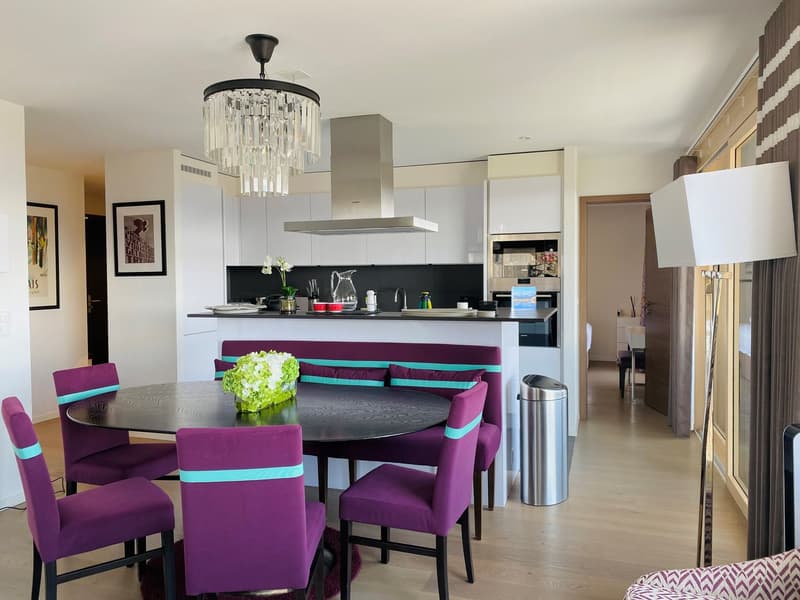 modern kitchen with dining area, round table, purple chairs, chandelier, white cabinets, wooden floor