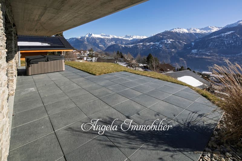 Outdoor area with large terrace and hot tub overlooking mountain range