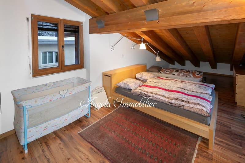bedroom with wooden bed, crib, rug, wooden ceiling, window, lamps