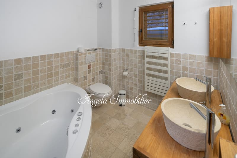 Bathtub, two sinks, toilet, radiator, wooden cabinet, tiled walls