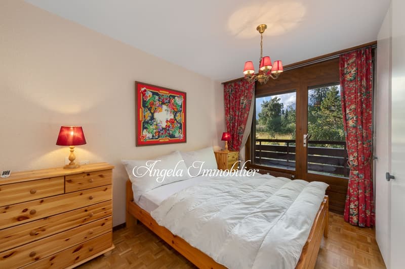 double bed, white bedding, wooden dresser, lamps, artwork, chandelier, large window with view, wooden floor