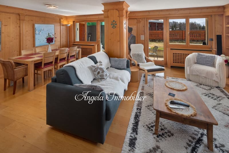wooden interior, dining table, sofa, chairs, wooden coffee table, carpet, paintings, sliding doors, mountains in view