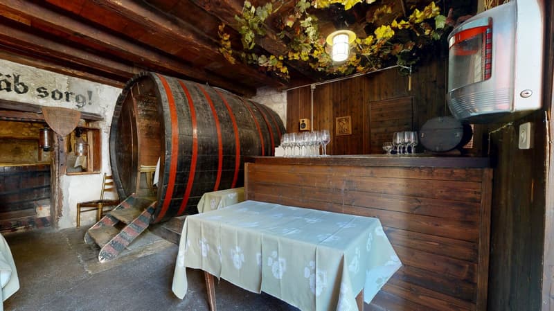 dining room, wooden floor, wooden wall, a large wooden barrel, a table with a cloth, wine glasses on a counter