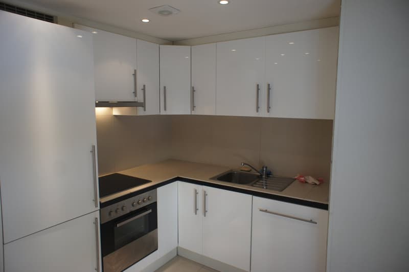 modern kitchen with white cabinets, stainless steel appliances, granite countertops, and a sink with a faucet