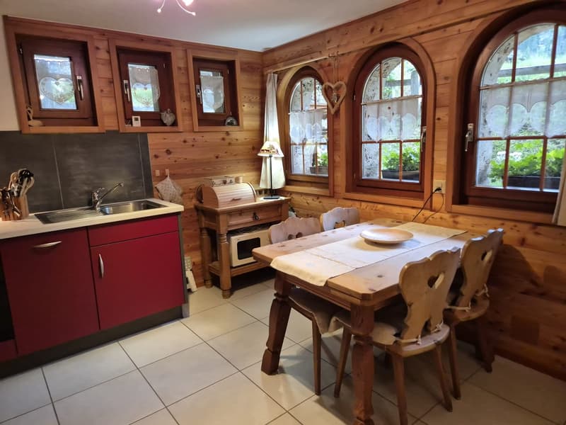 wooden wall, tiled floor, wooden table, sink, microwave, cabinet, lamp, chair