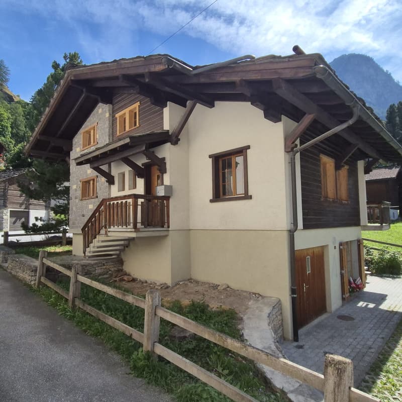 Small house, wooden beams, stone wall, stairs to wooden terrace, windows, wooden door, wooden fence.