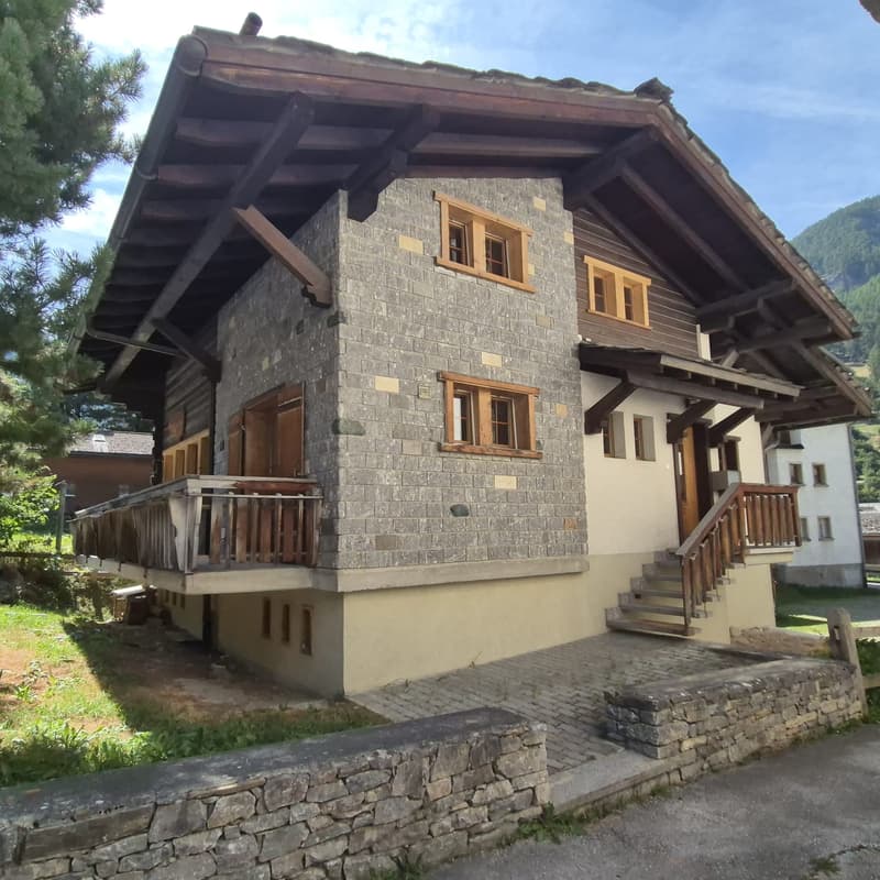 Detached house, wooden slat beams, stone facade, two windows, entrance with steps, wooden balcony, small courtyard, garden, mountain view