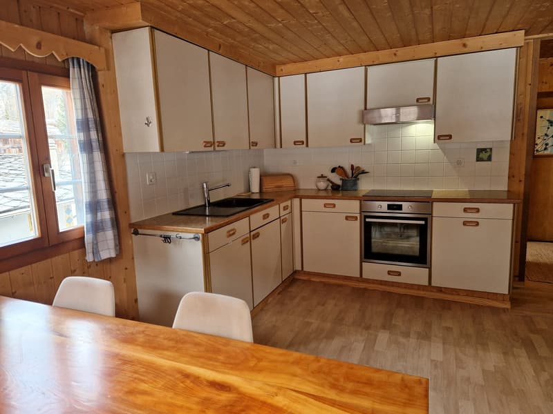 kitchen with wooden floor, white cabinets, sink, oven, window with curtain