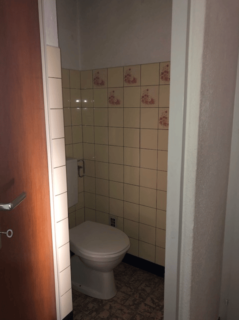 Compact bathroom, ceramic tiles, white toilet, single wall, no window