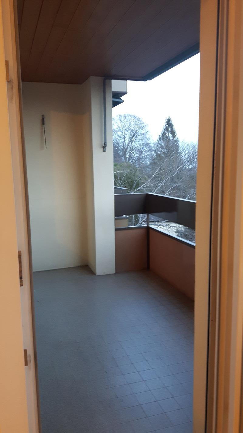 empty balcony with tiled floor, metal railing, view of trees