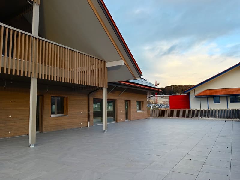 building with wooden walls, balcony, parking area, fence