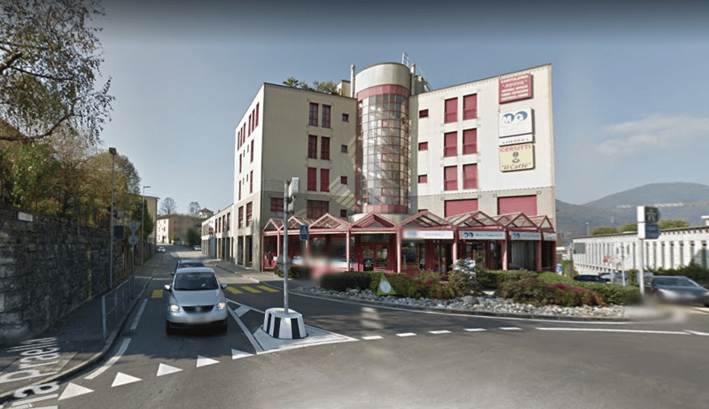 commercial building, large glass windows, ground level, signage, parking area