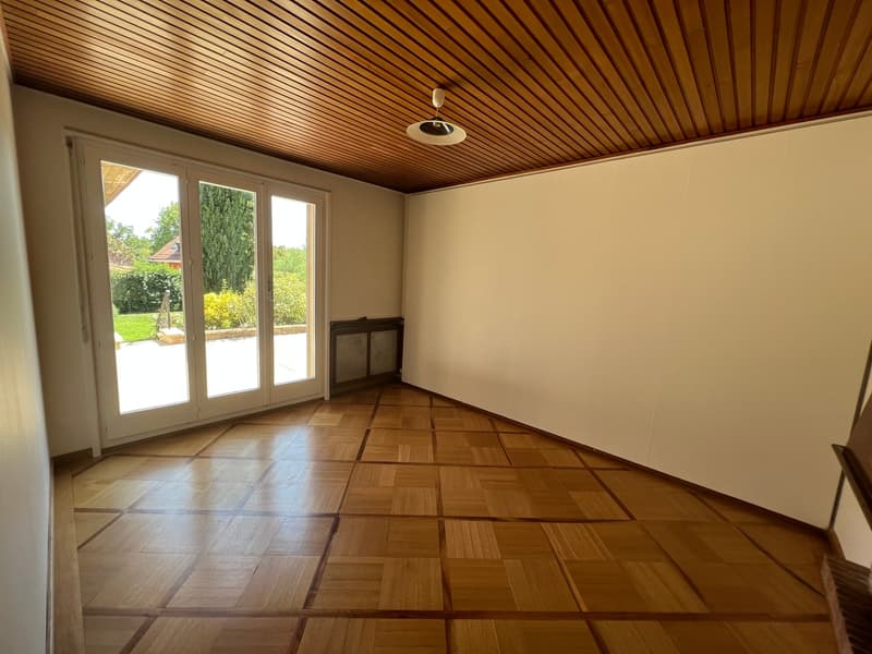 room with sliding glass doors, wooden floor, ceiling, white walls, lamp