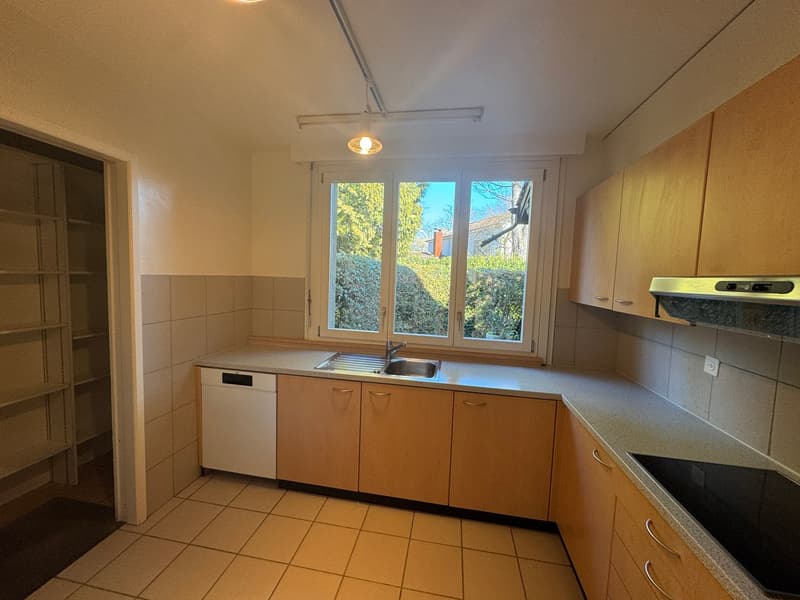 Kitchen with dishwasher, sink, kitchen cabinets, open window, light, and tiled floor.