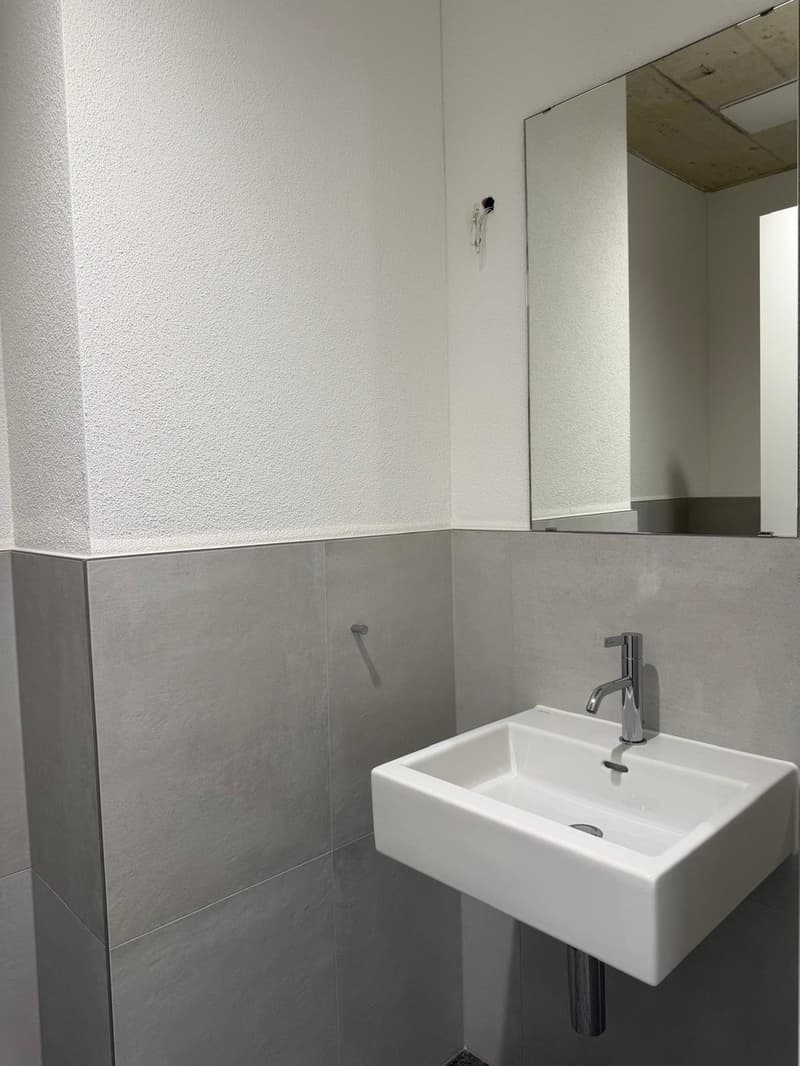white sink, silver faucet, mirror, tiled walls