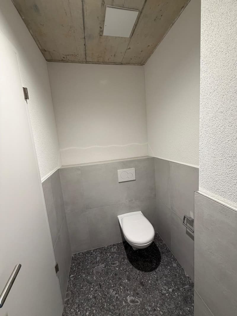 small bathroom with toilet, power outlet on wall