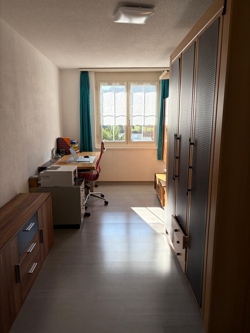 Office room with desk, chair, printer, laptop, and window with curtains