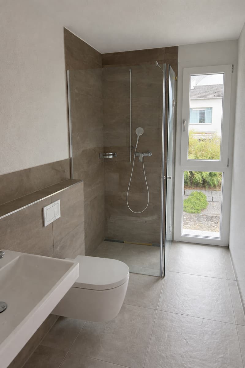 modern bathroom with glass shower, white toilet, white sink, tiled floor, white walls
