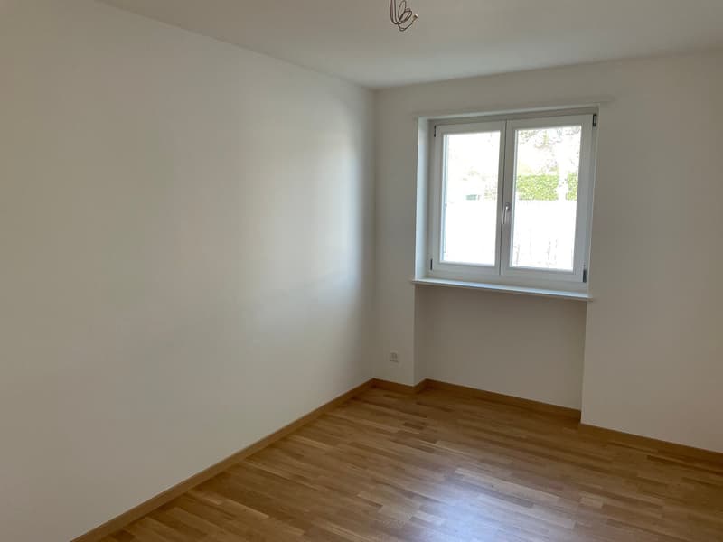 empty room, wooden floor, white walls, window, power outlet
