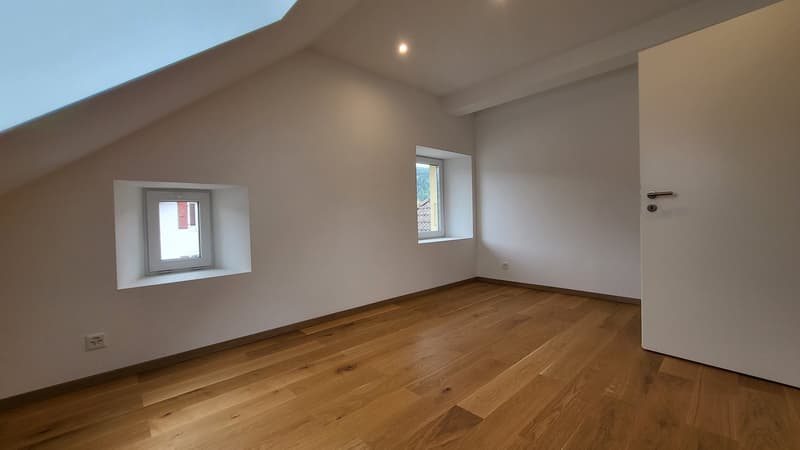 empty room, wooden floor, white walls, two windows, slanted ceiling